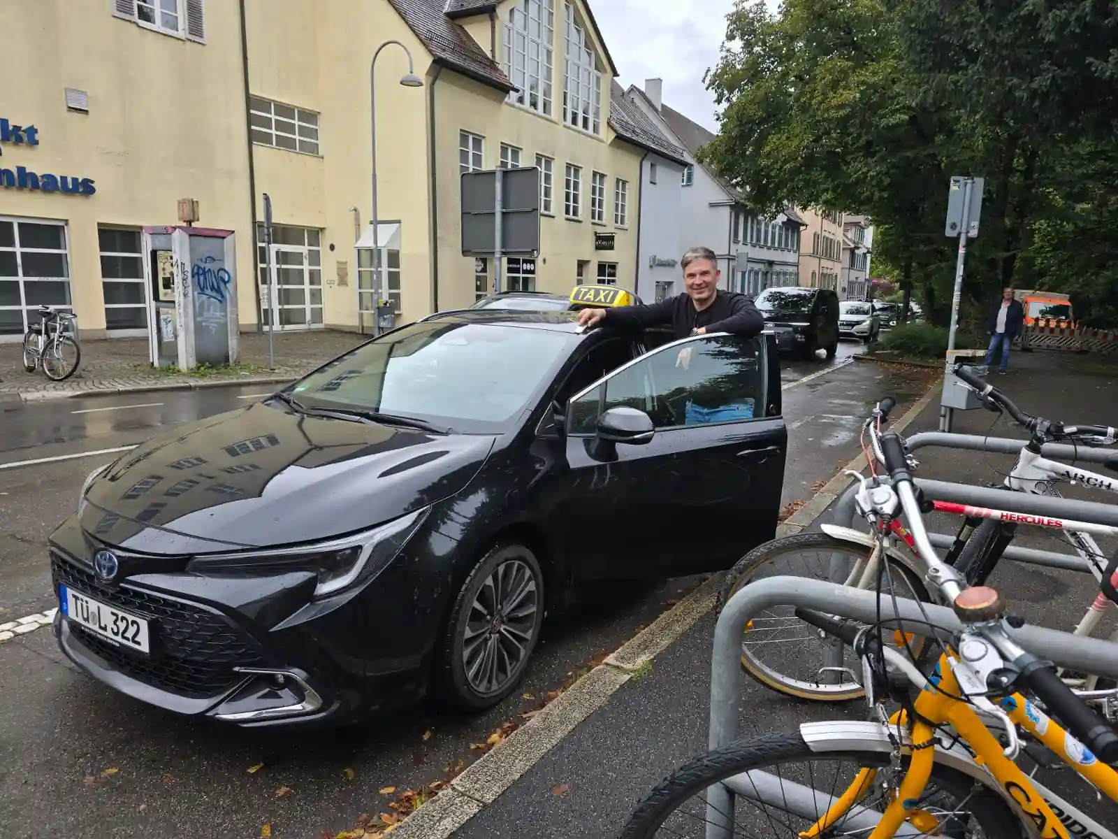 Taxista Fahrer neben einem schwarzen Taxi in Tübingen